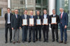 Group of people standing side by side holding plaques to indicate  winning Supplier of the Year award from Rolls Royce MTU